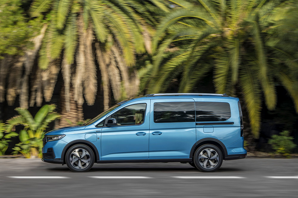 Un fourgon Plug-in Hybrid Ford Tourneo Connect bleu garé dans une rue.