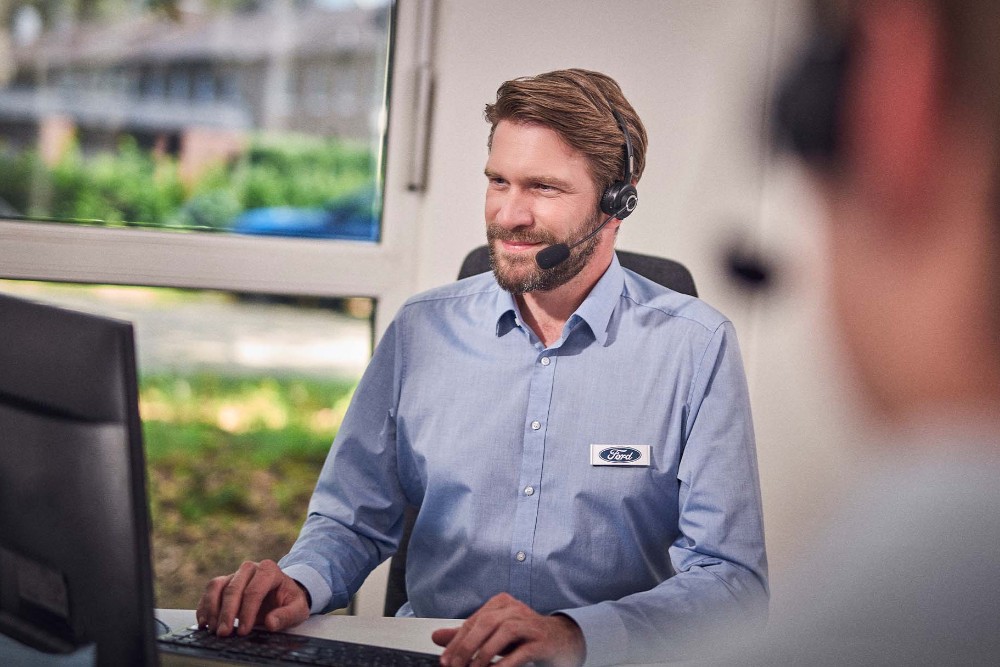 A Ford employee talking on a headset