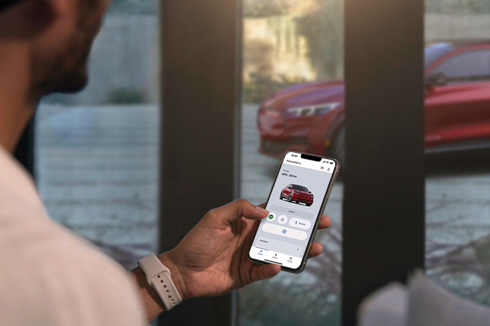 A man checking the settings of his All-New Ford Mustang Mach-E using the Remote Vehicle Control features in the Ford App