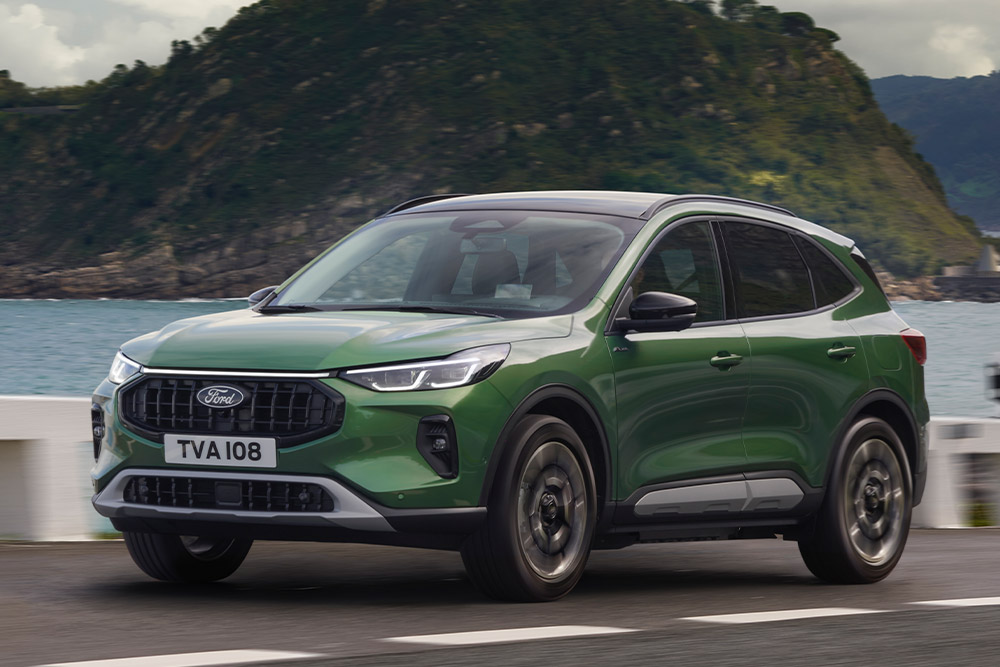 Un Ford Kuga vert roulant sur une route côtière.