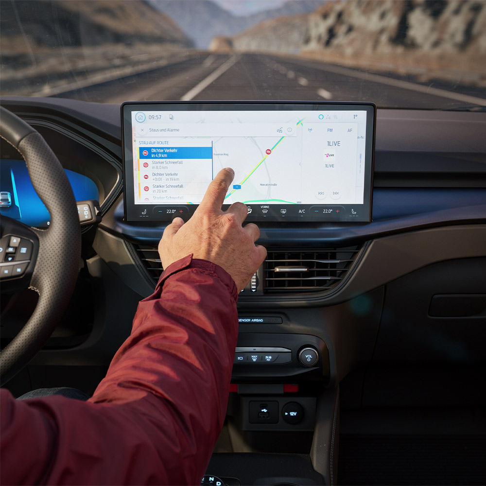 Un conducteur utilisant la fonctionnalité de Navigation Connectée sur l’écran numérique d’un Ford KugaBlueCruise Edition.