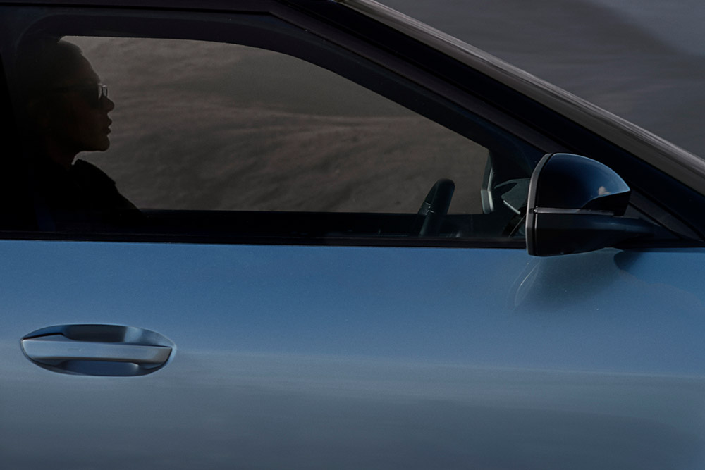 Gros plan de la portière d’un Ford Explorer® bleu. 