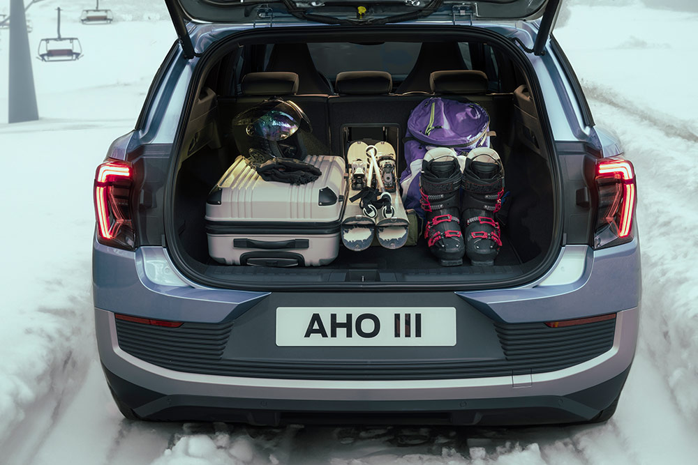 L’espace pour bagages arrière du Ford Explorer accueillant une valise blanche et des équipements de ski placés en travers du coffre.