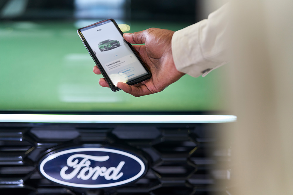 Un homme consulte l'application Ford depuis un smartphone