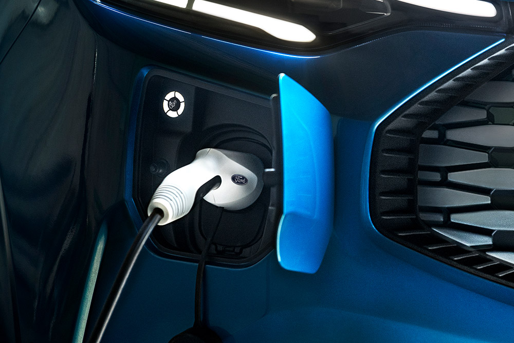 Fourgon bleu Ford Transit hybride rechargeable en cours de recharge.