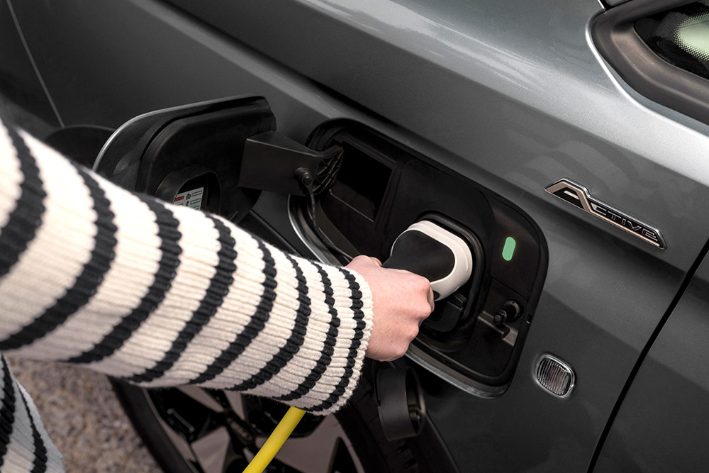 Une personne branchant un câble de recharge sur un Ford Transit Connect hybride rechargeable.