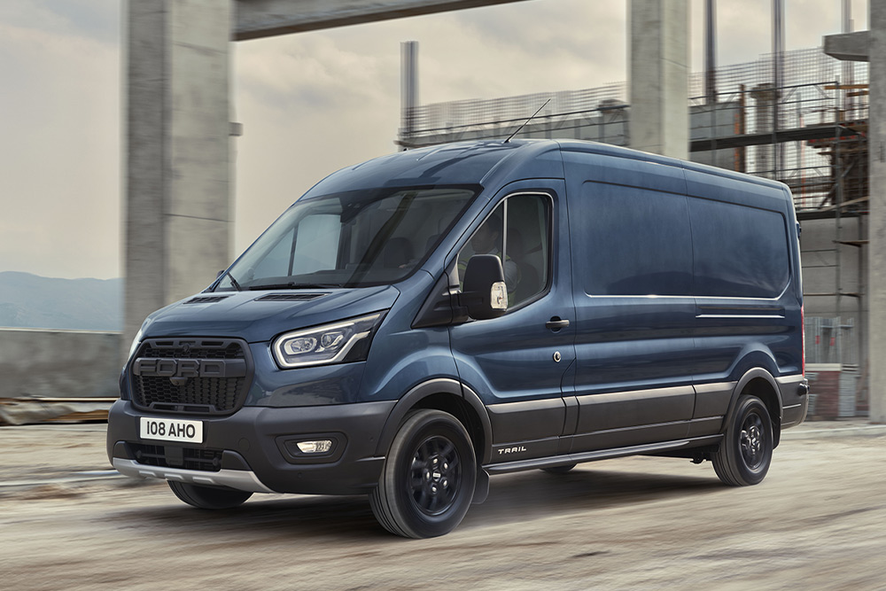 Fourgon Ford Transit avec pack Trail en option circulant dans une zone industrielle. 