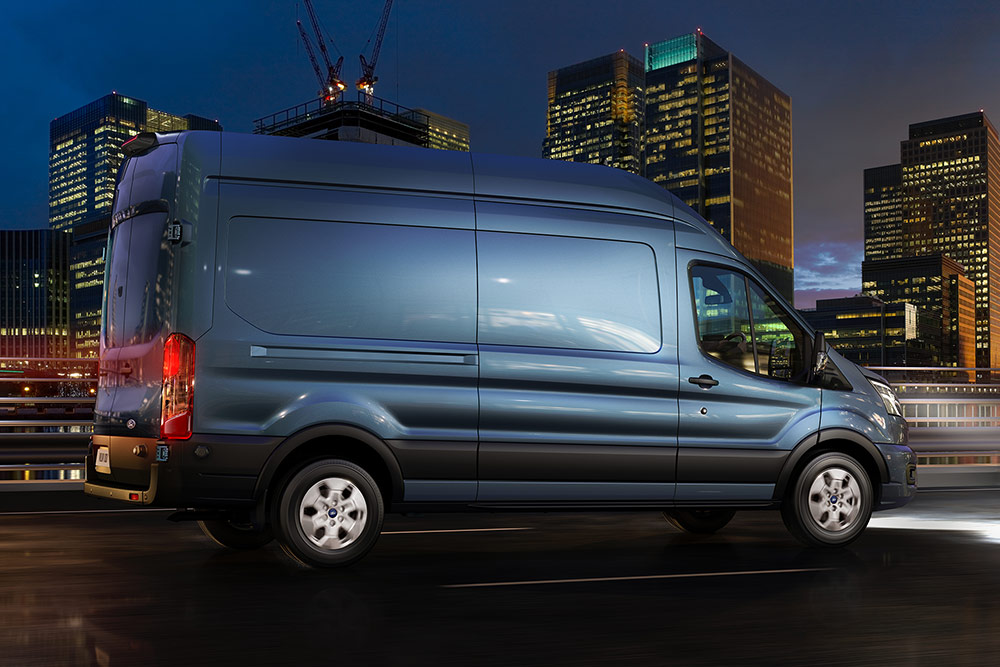 Fourgon Ford Transit circulant en ville de nuit.
