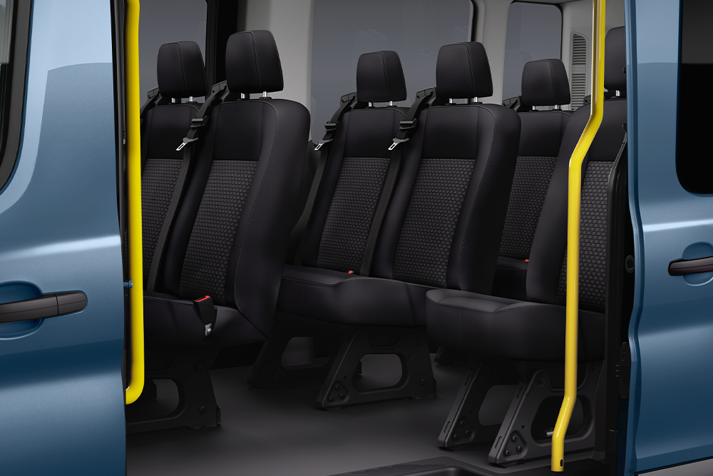 Vue sur les sièges passagers du Ford Transit Kombi à travers la porte latérale coulissante.