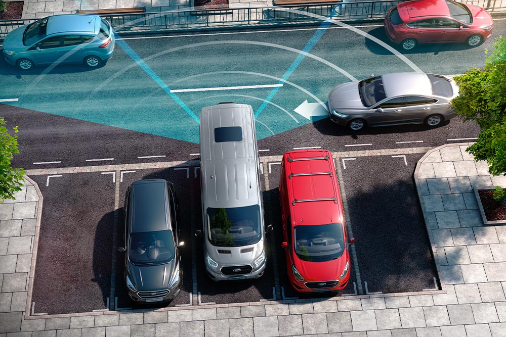 Fourgon Ford Transit argenté en marche arrière, avec des lignes bleues représentant l’utilisation des capteurs de stationnement arrière.