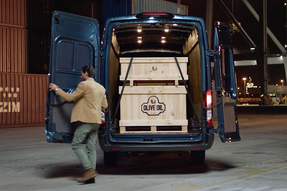 Fourgon Ford Transit avec portes arrière ouvertes, chargement à l’intérieur.