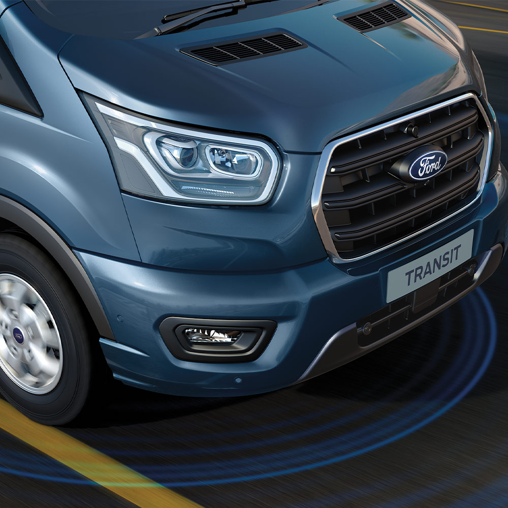 Fourgon Ford Transit bleu avec des lignes bleues sur la route illustrant l’utilisation des systèmes avancés d’aide à la conduite.