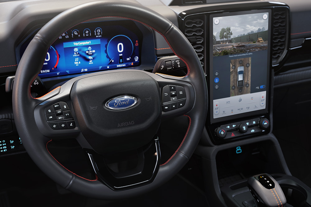 Vue intérieure du Ford Ranger Wildtrak montrant le volant, la console centrale et l’écran tactile SYNC™ 4 de 12 pouces.